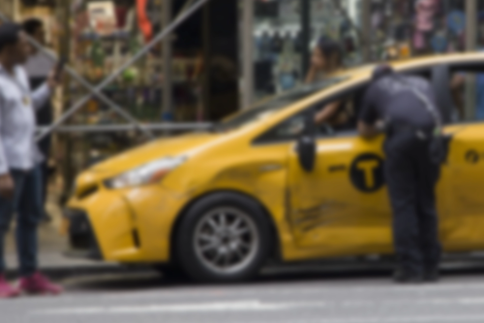 blurred image of a dented NYC taxi cab